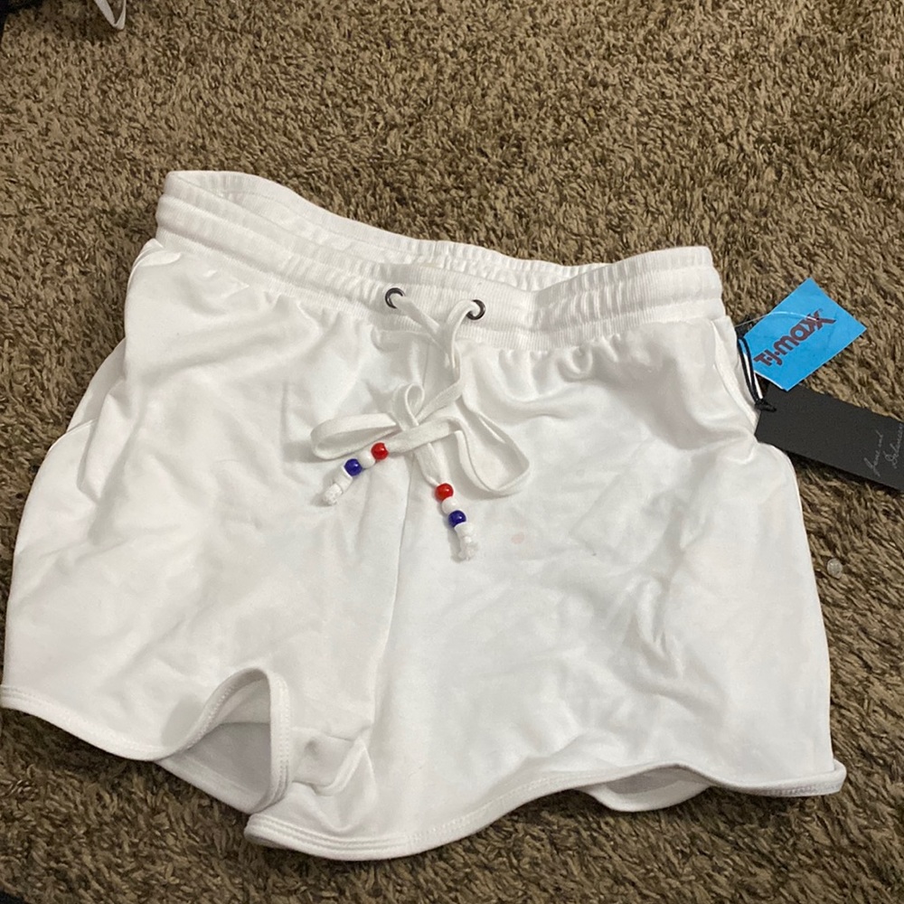 A white pair of shorts with strings with white blue and red beads size small